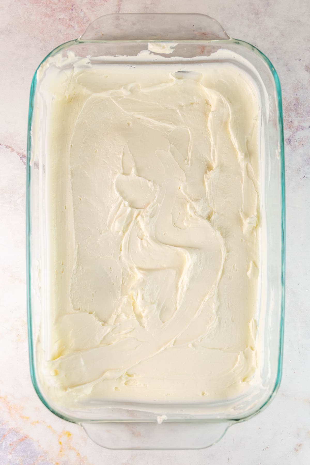 baking dish filled with a layer of softened cream cheese