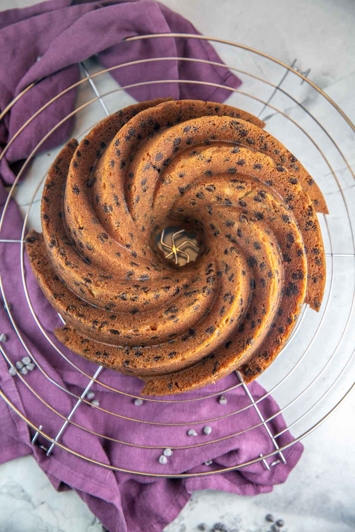 Chocolate chip bundt cake after being baked, sitting on a cooling wrack. 