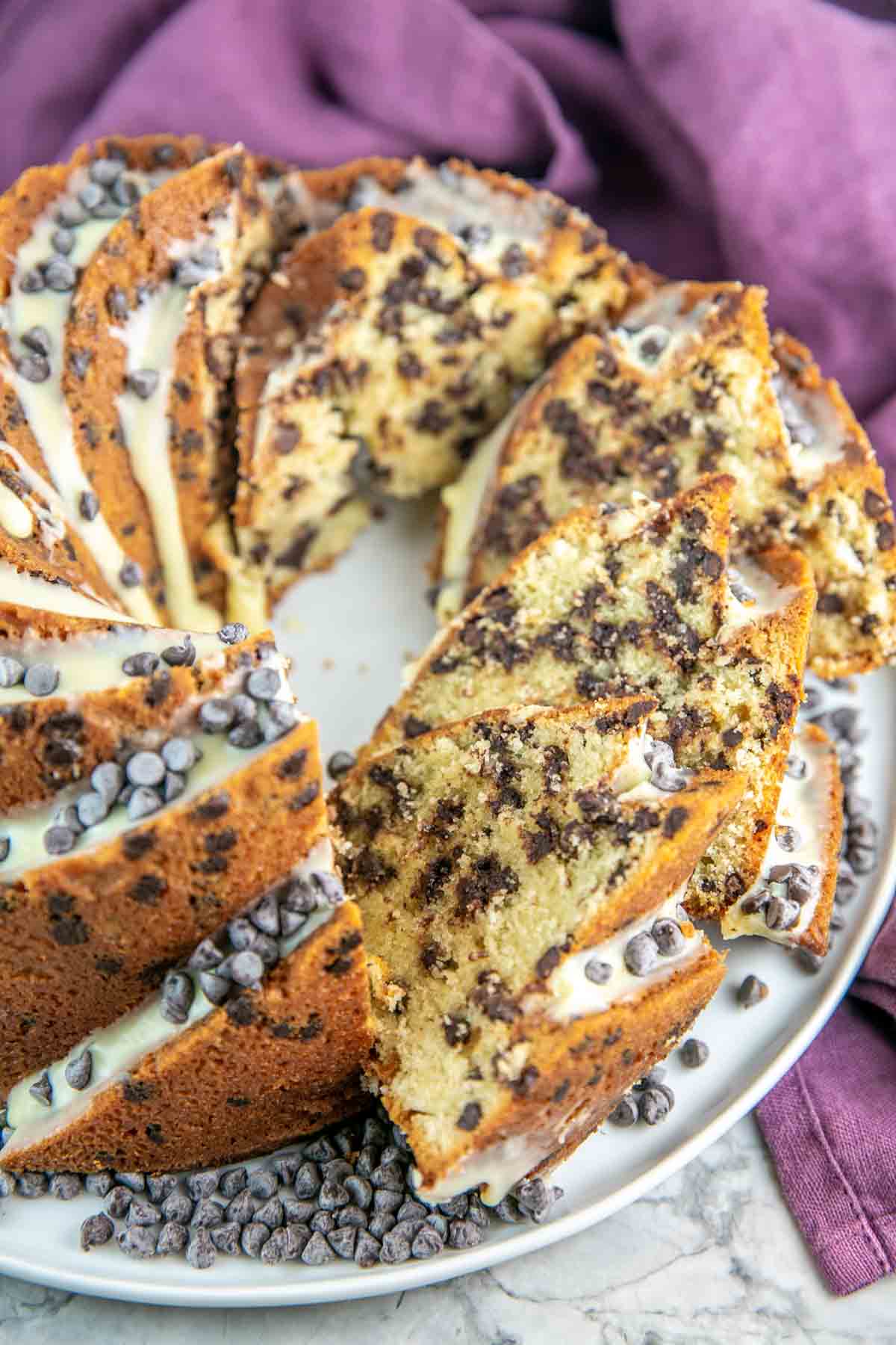 Chocolate chip bundt cake cut into slices on a white platter.
