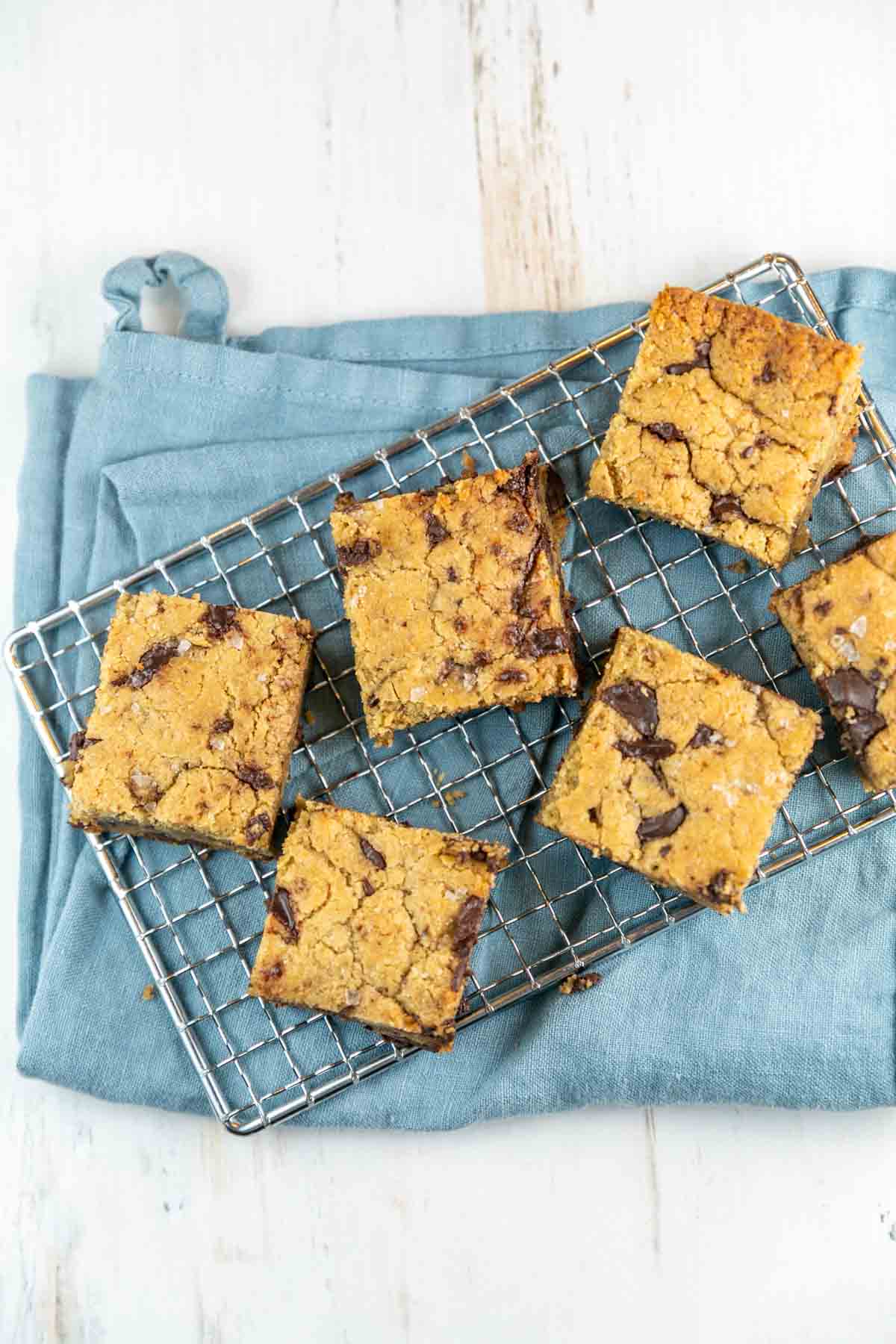 six large chocolate chip tahini blondies on a wire cooling rack