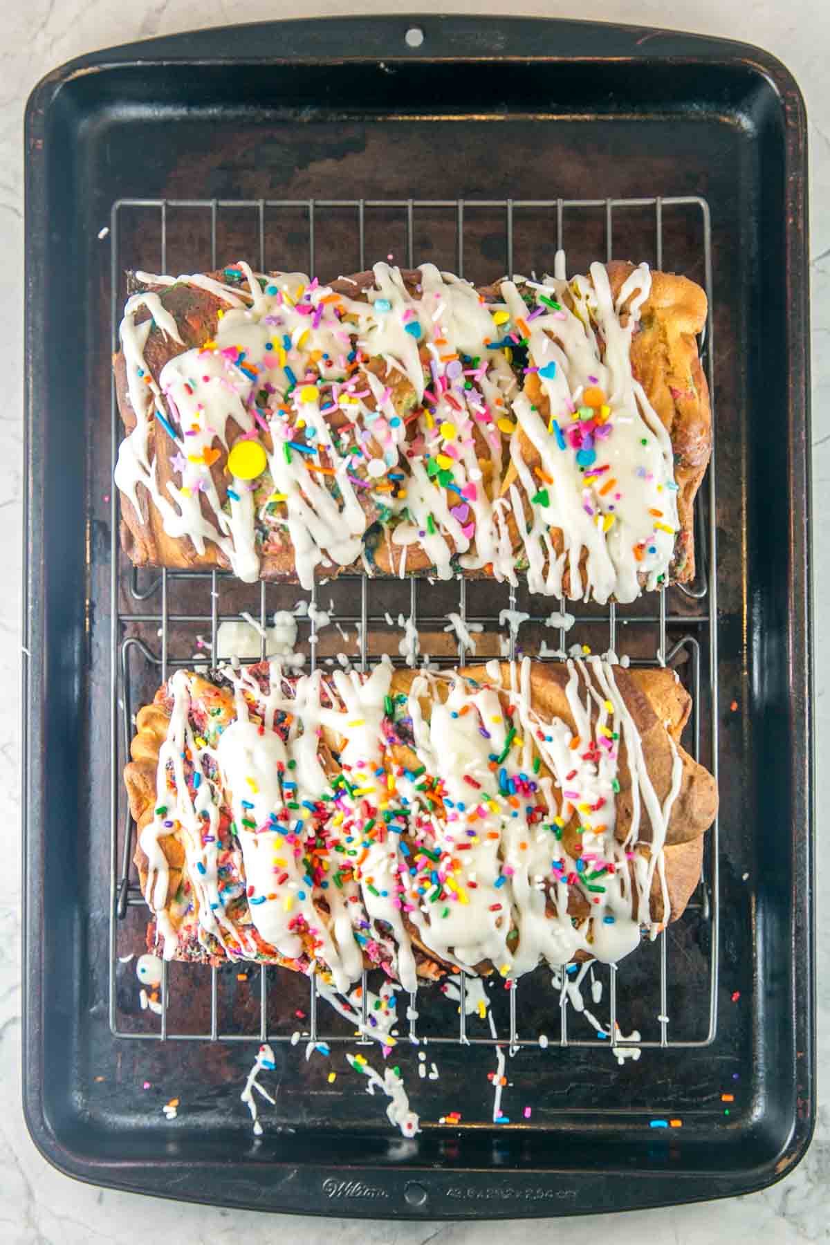 overhead view of two loaves of babka drizzled with glaze on a cooling rack