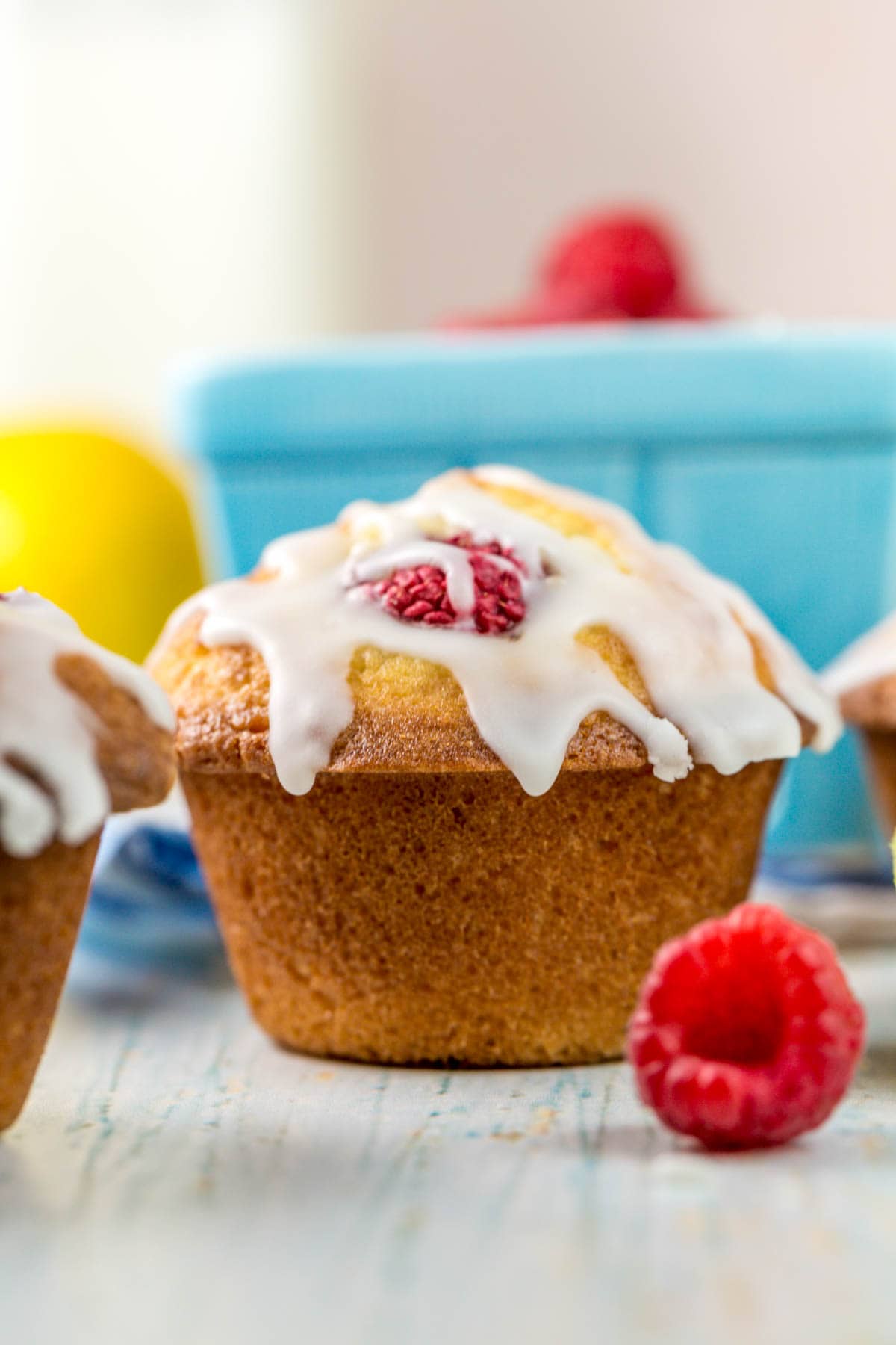 side view of a muffin with lemon glaze dripping off the domed top