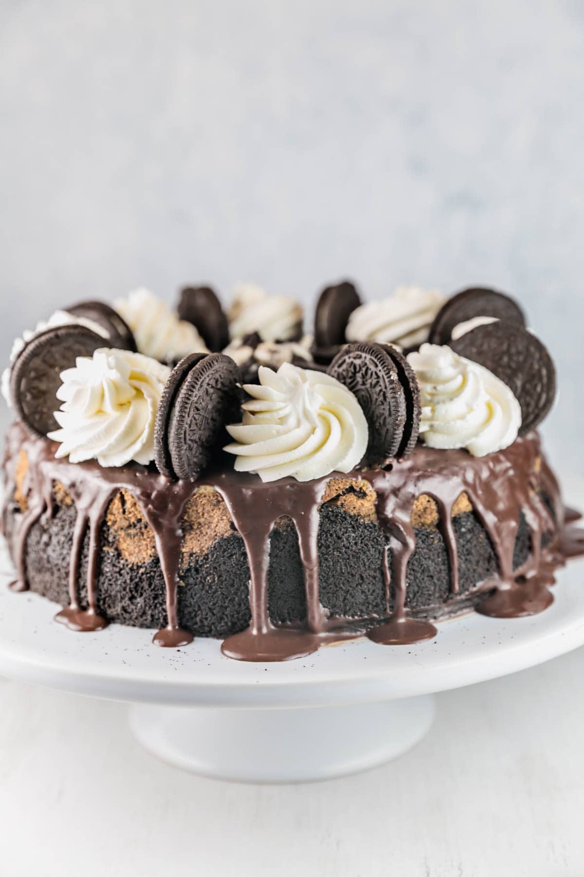 cheesecake decorated with ganache, whipped cream, and oreos