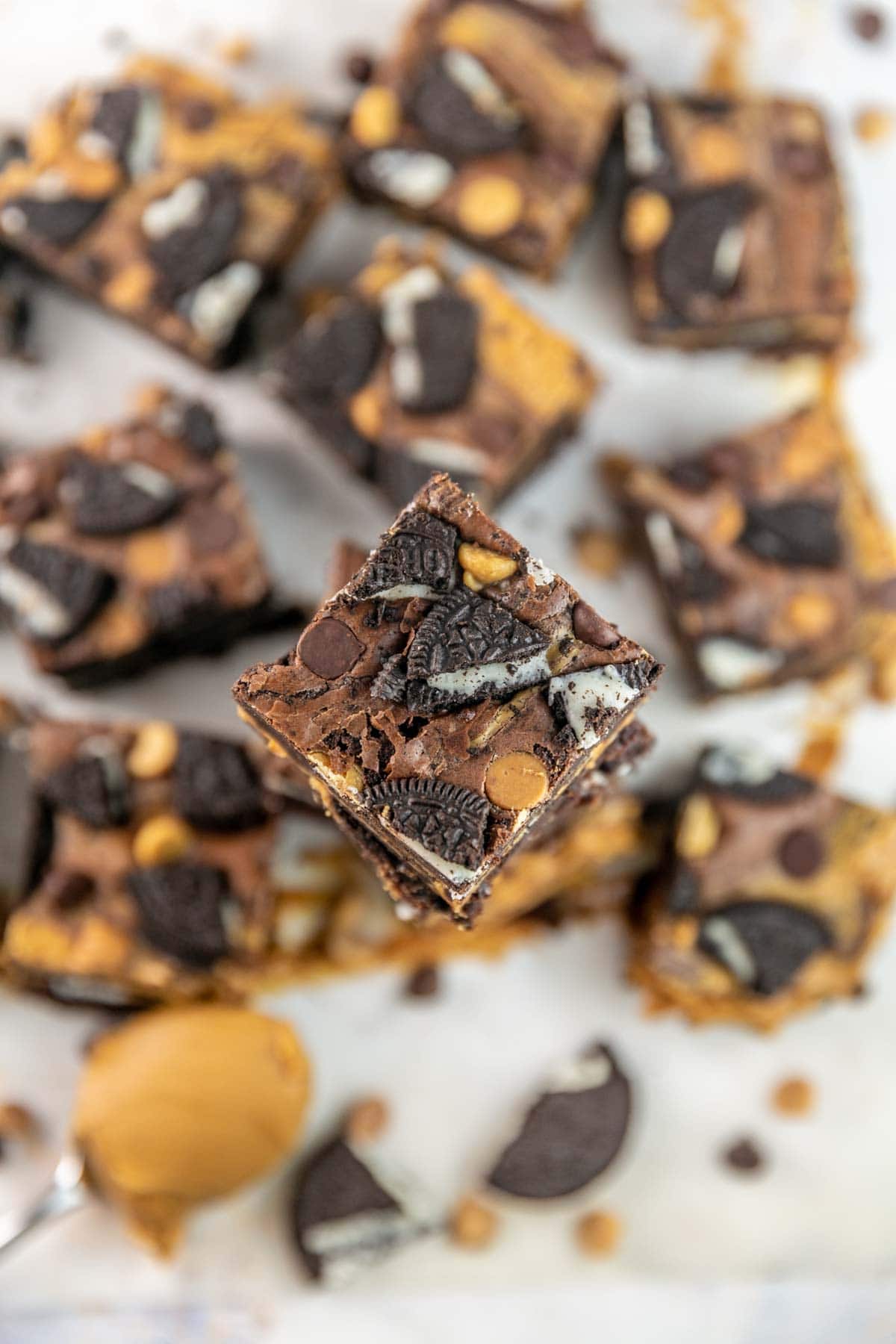 Top view of brownies stacked on top of each other with more brownies in the background. 