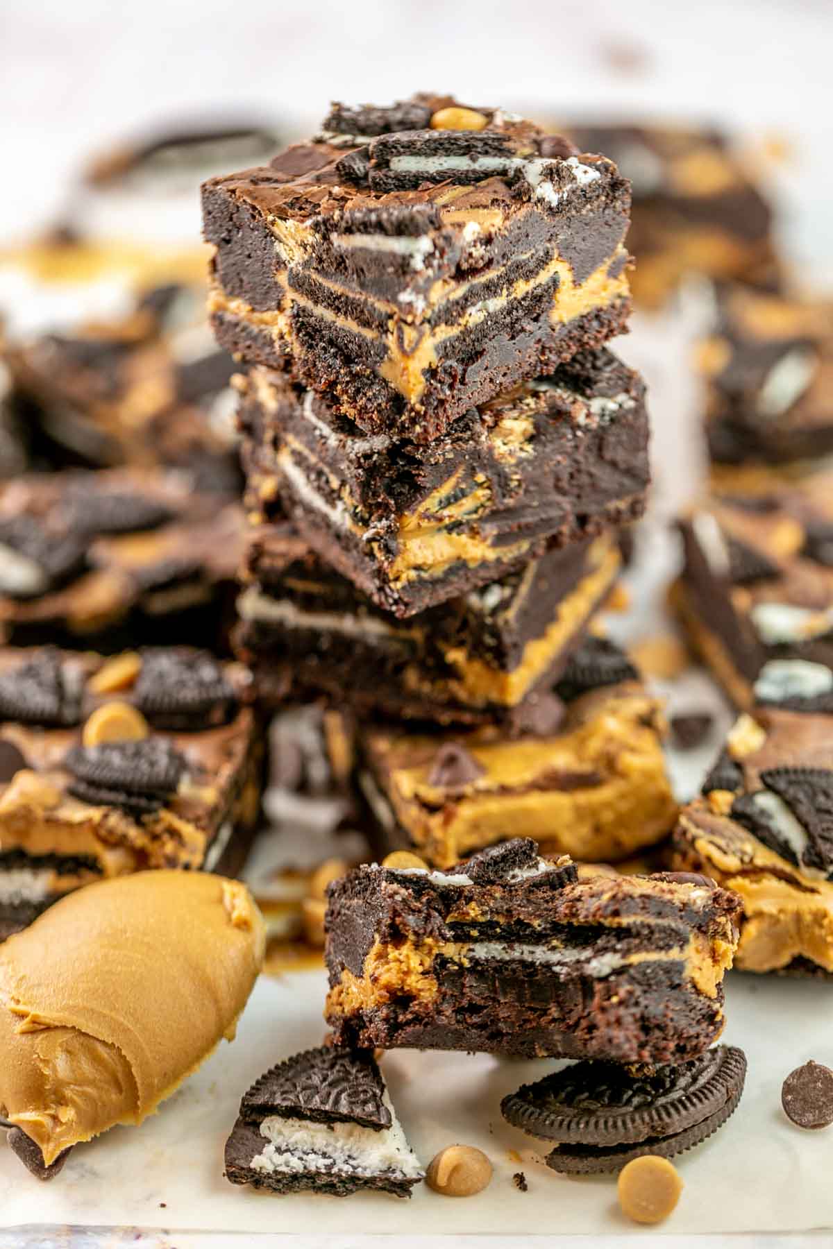 Stack of peanut butter Oreo brownies with one brownie missing a bite. 
