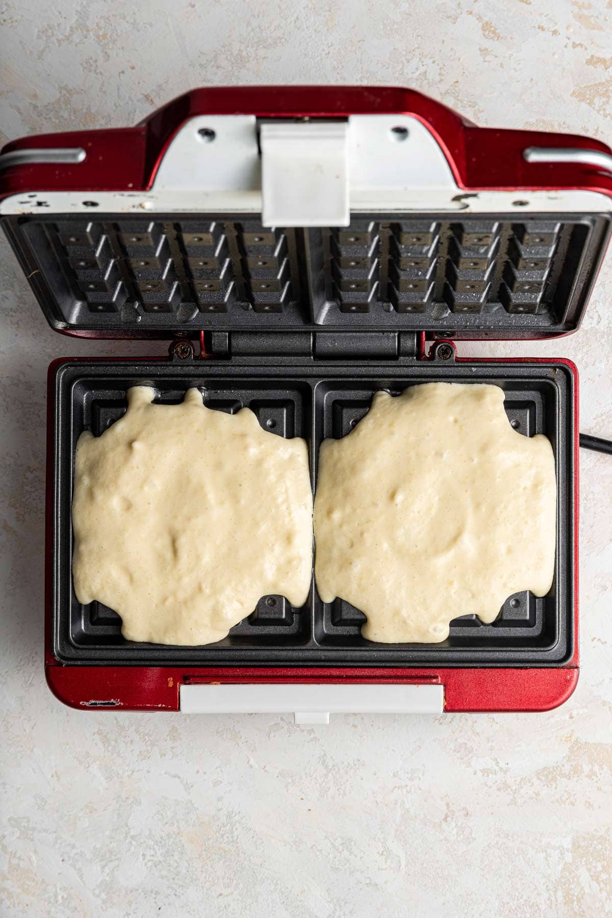 waffle batter poured into a square waffle iron