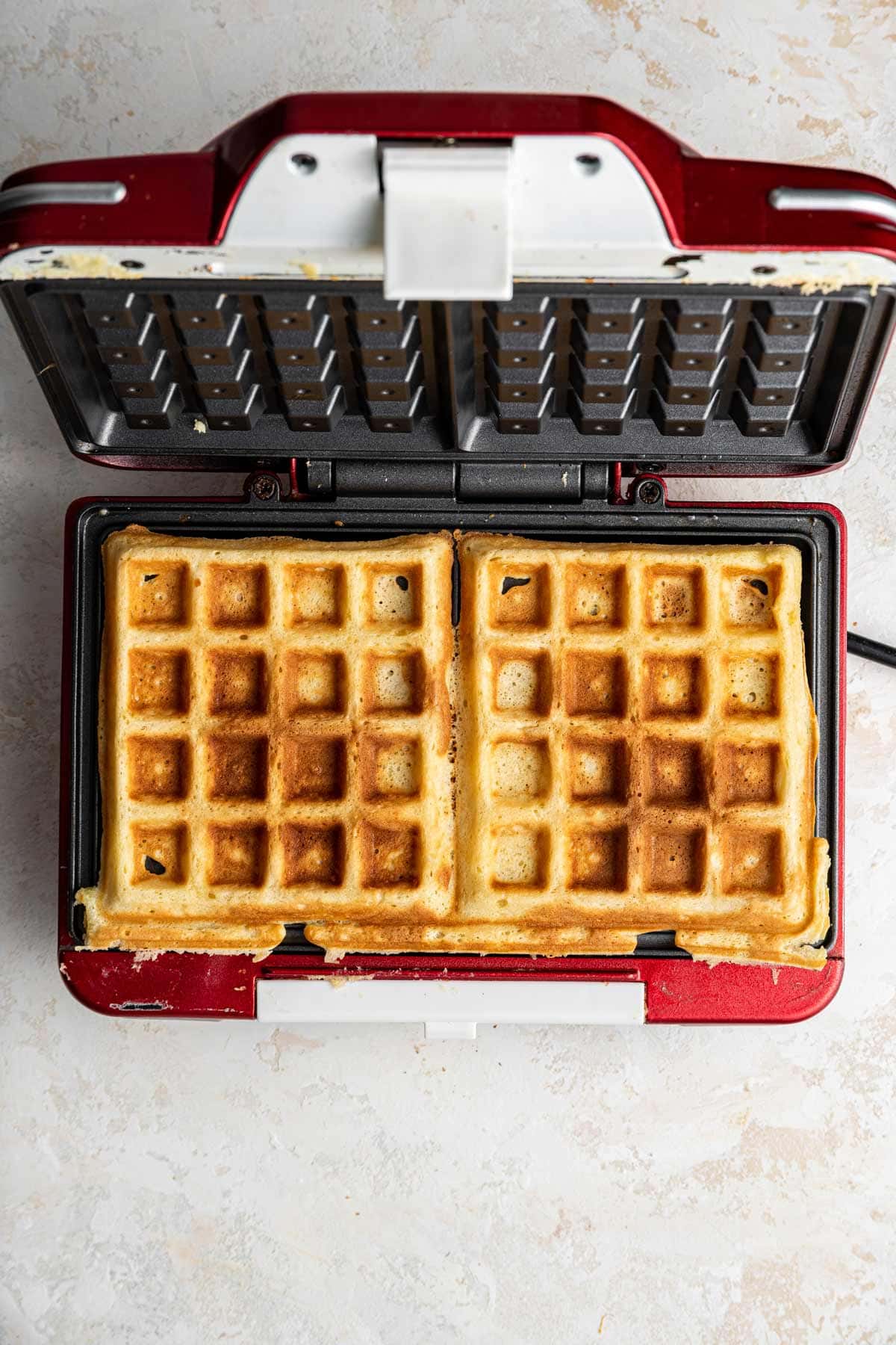 perfectly golden and crispy belgian waffles still in the waffle iron