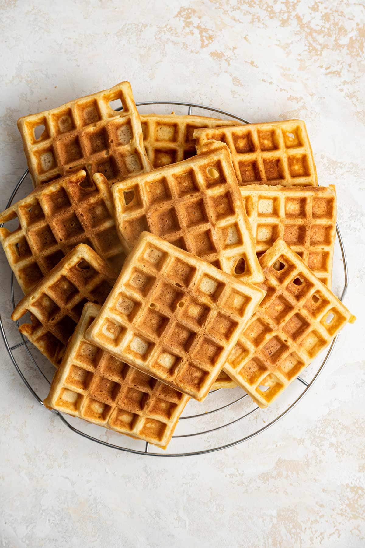 a stack of square belgian waffles on a round cooling rack