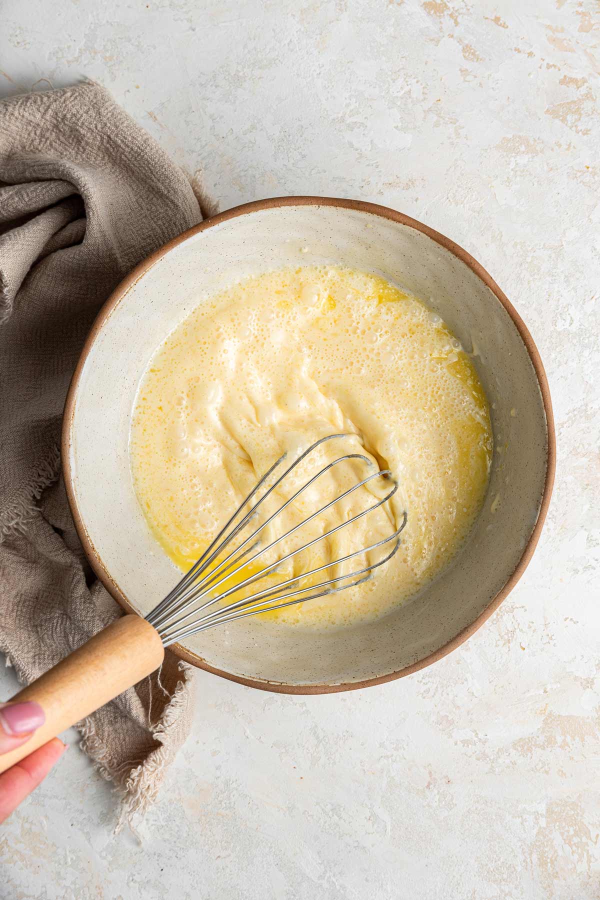 hand whisking together the batter to make belgian waffles