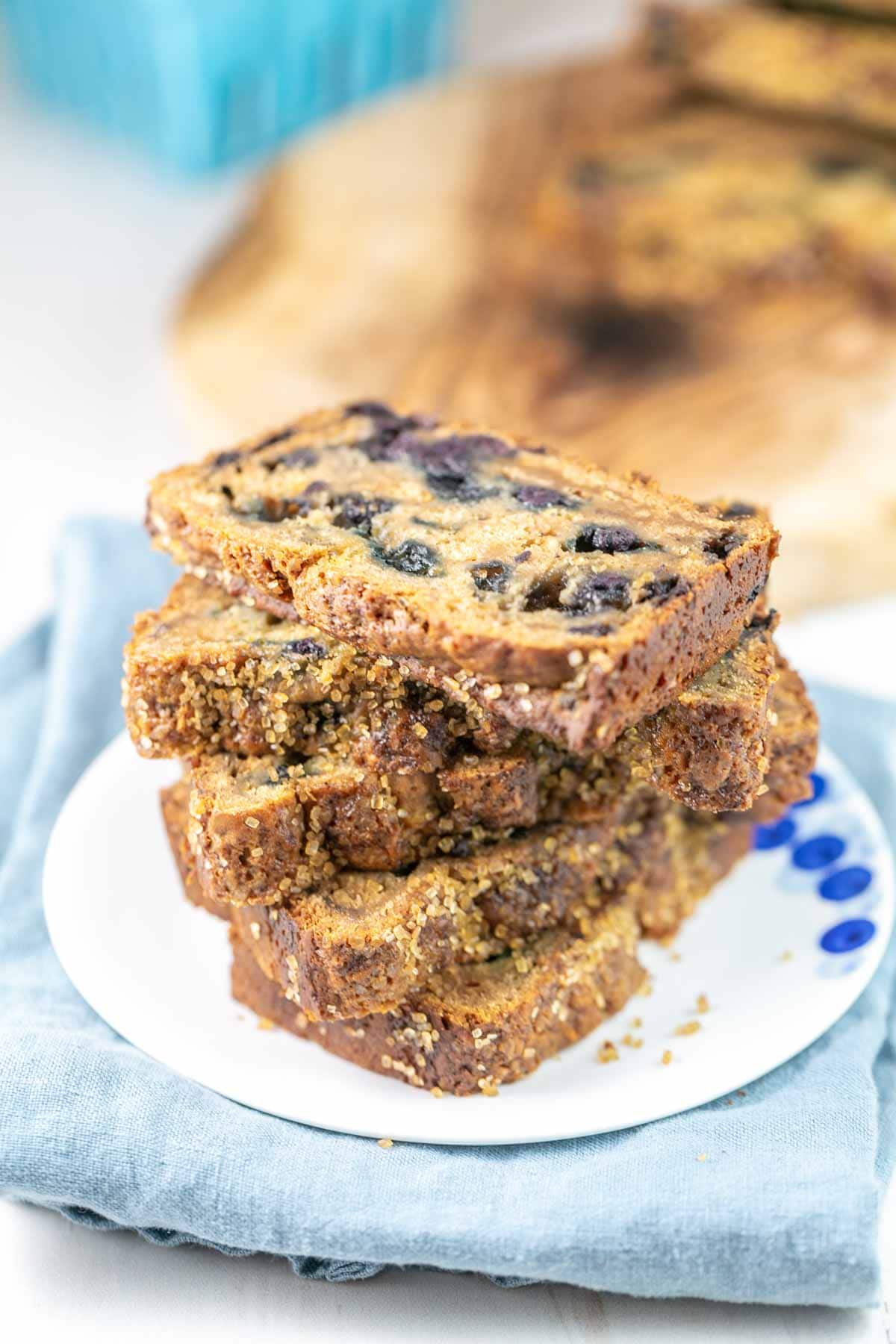 slices of blueberry bread with sugar crystals on a blueberry-themed dessert plate