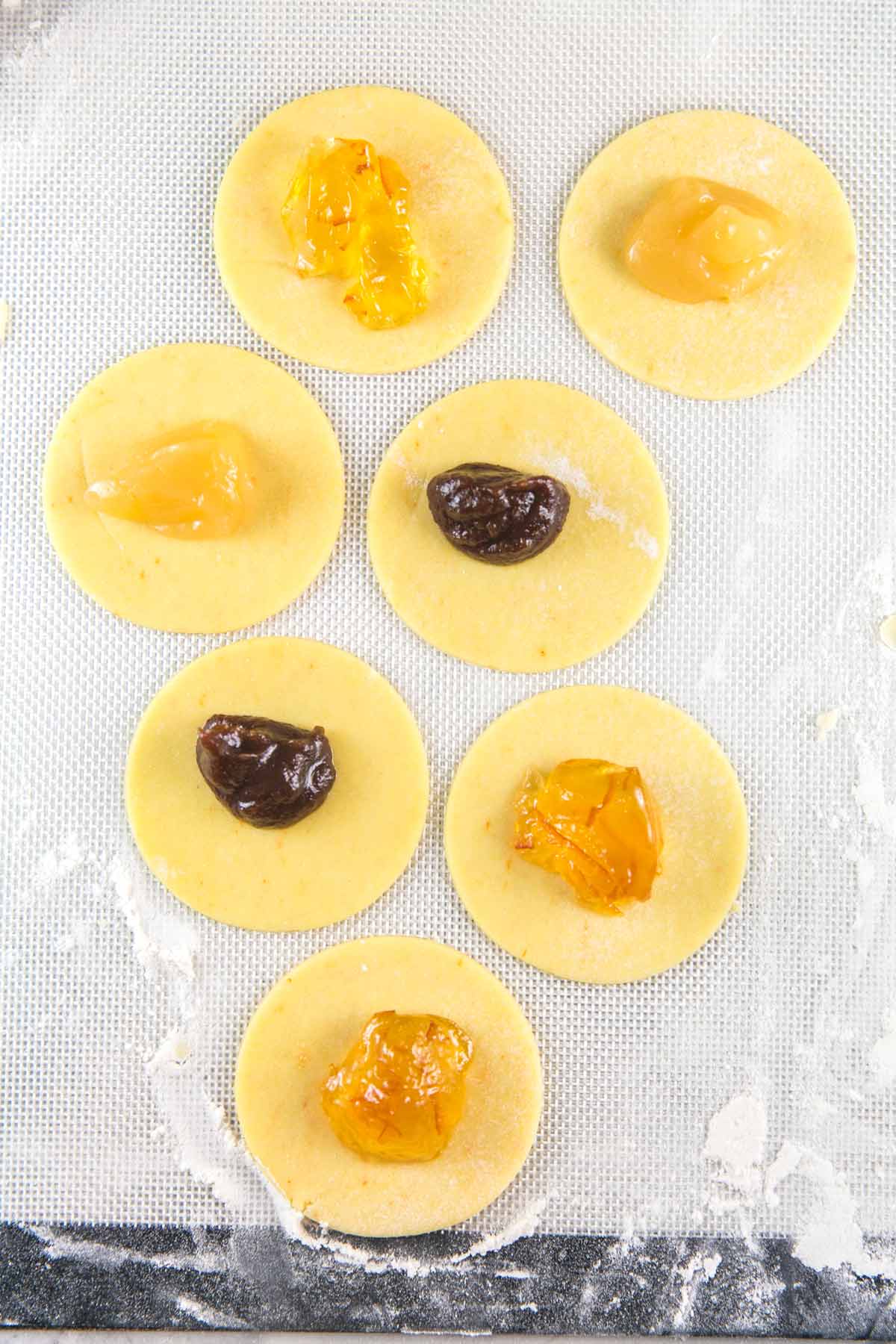 circles of cake mix hamantaschen dough with dollops of filling in the center