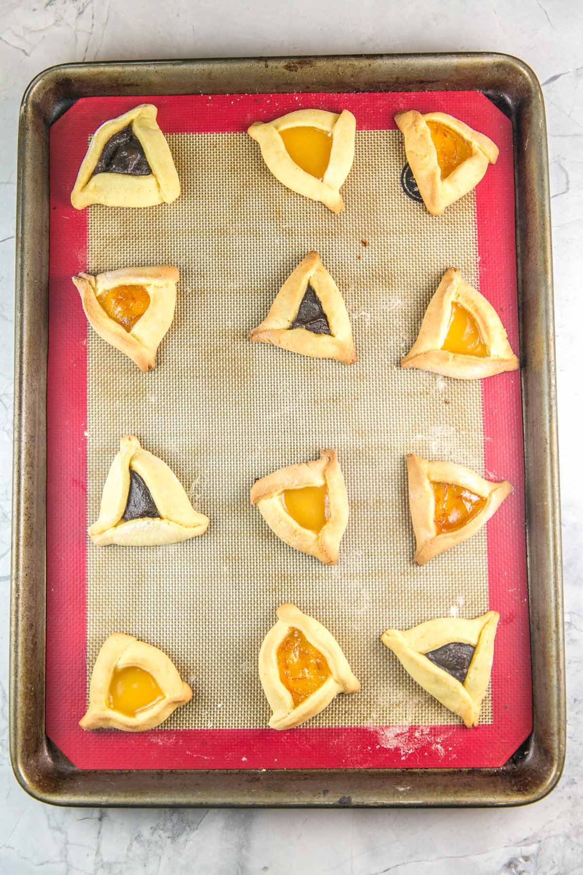 baked hamantaschen on a cookie sheet