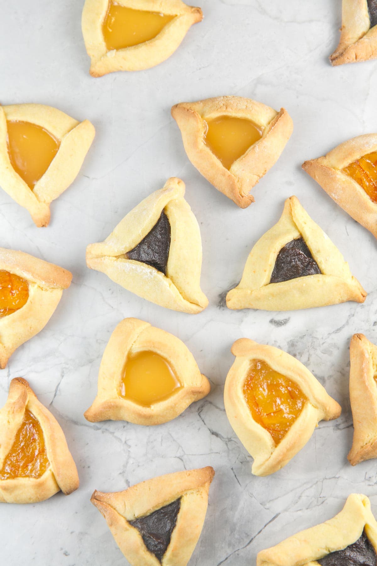 overhead photo of baked cake mix hamantaschen on a marble counter