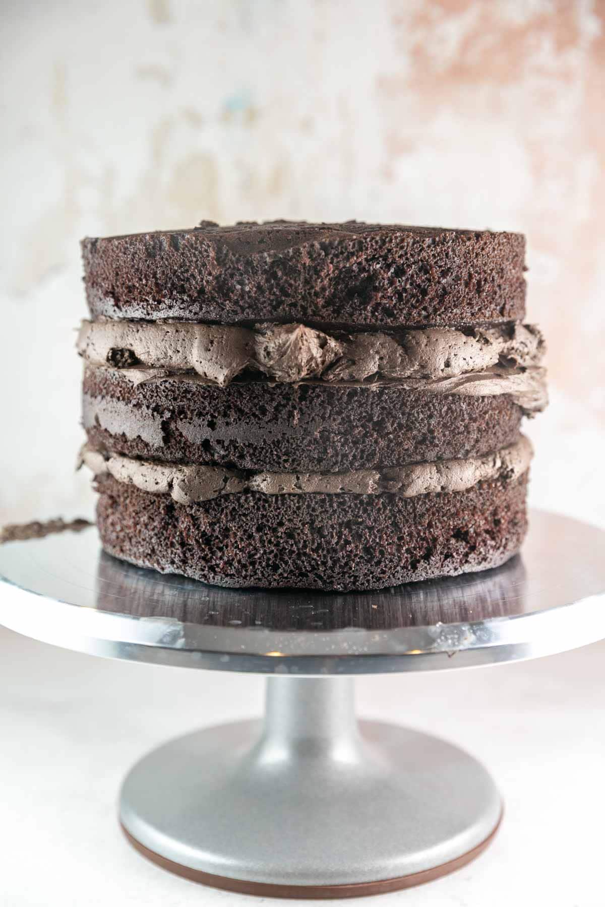 three layers of cake with a thick layer of chocolate buttercream between each