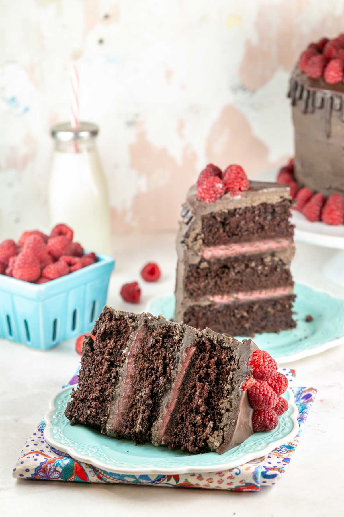 slice of three layer cake with raspberry curd filling on its side on a blue dessert plate