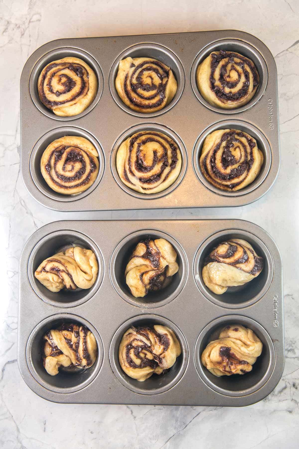 two muffin tins with unbaked babka muffin dough, one with circular swirls and one twisted in half