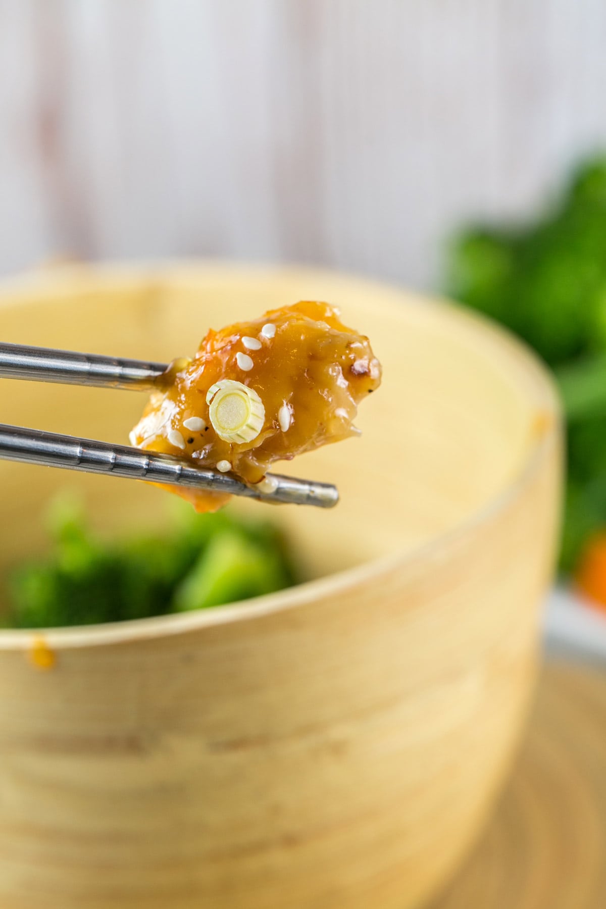 one piece of chicken held up by chopsticks