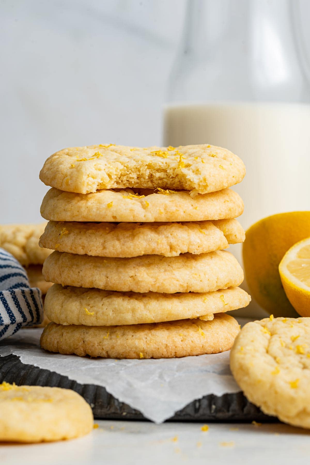 stack of lemon sugar cookies with one bite taken out of the top cookie