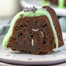 a slice of super fudgy chocolate bundt cake covered in green mint fudge frosting
