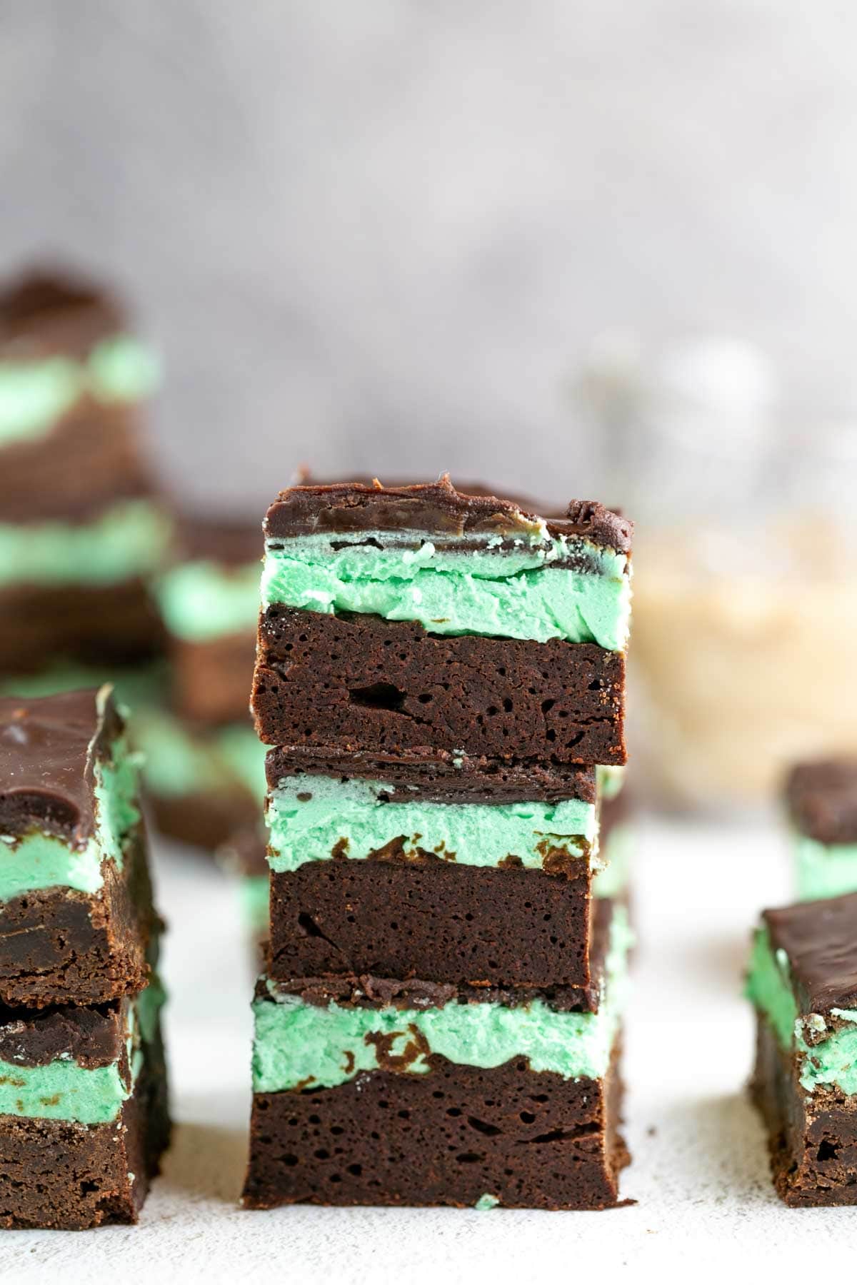 vertical stacks of thick brownies with a layer of green mint irish cream frosting