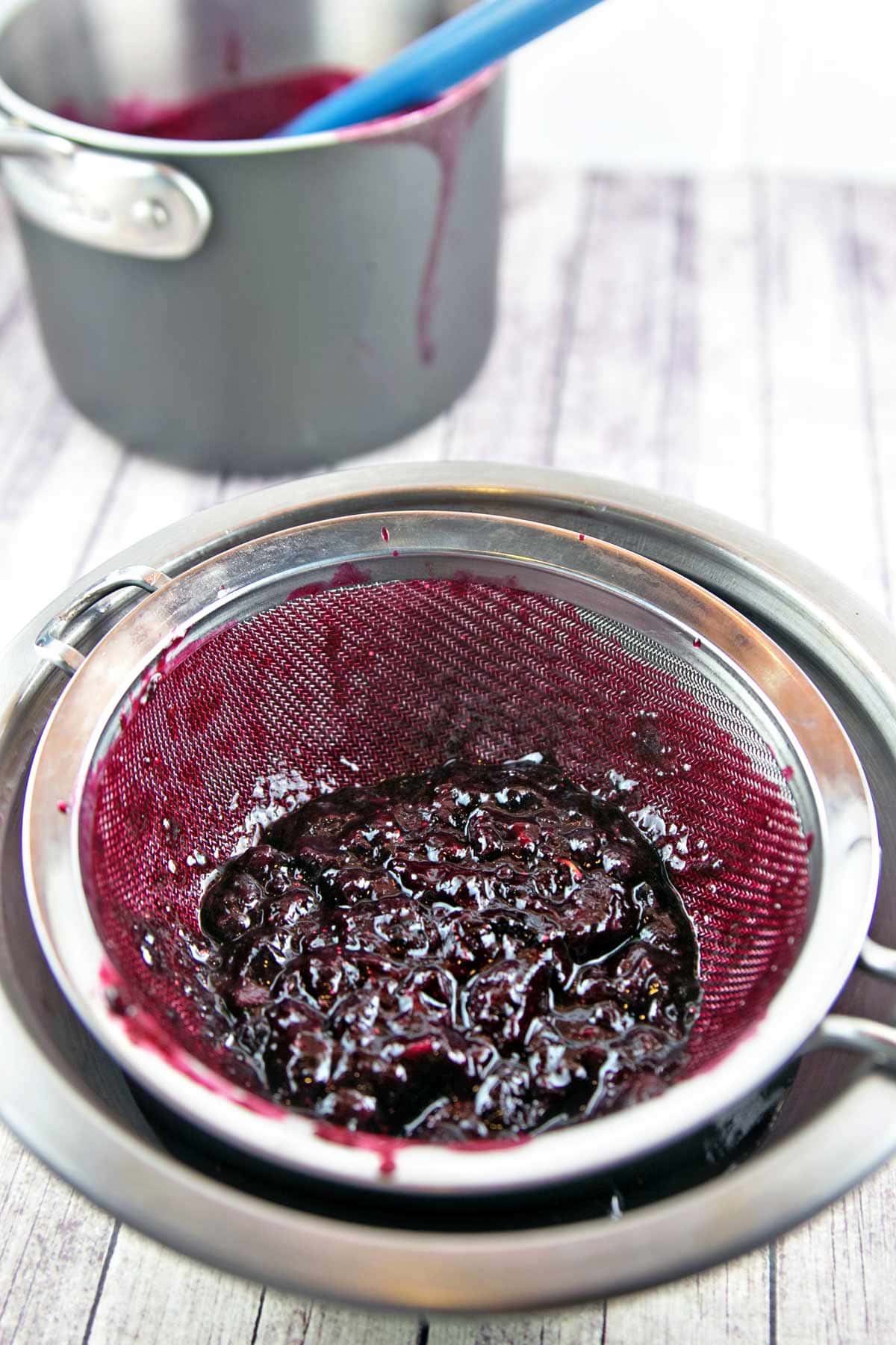 solids left behind after straining cooked blueberries through a fine mesh sieve