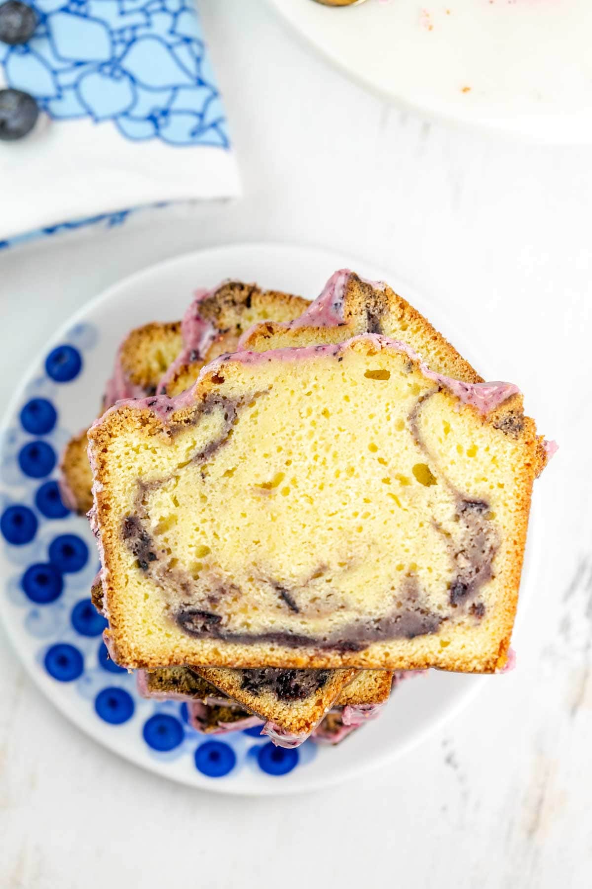 slices of pound cake stacked on a blueberry-themed dessert plate