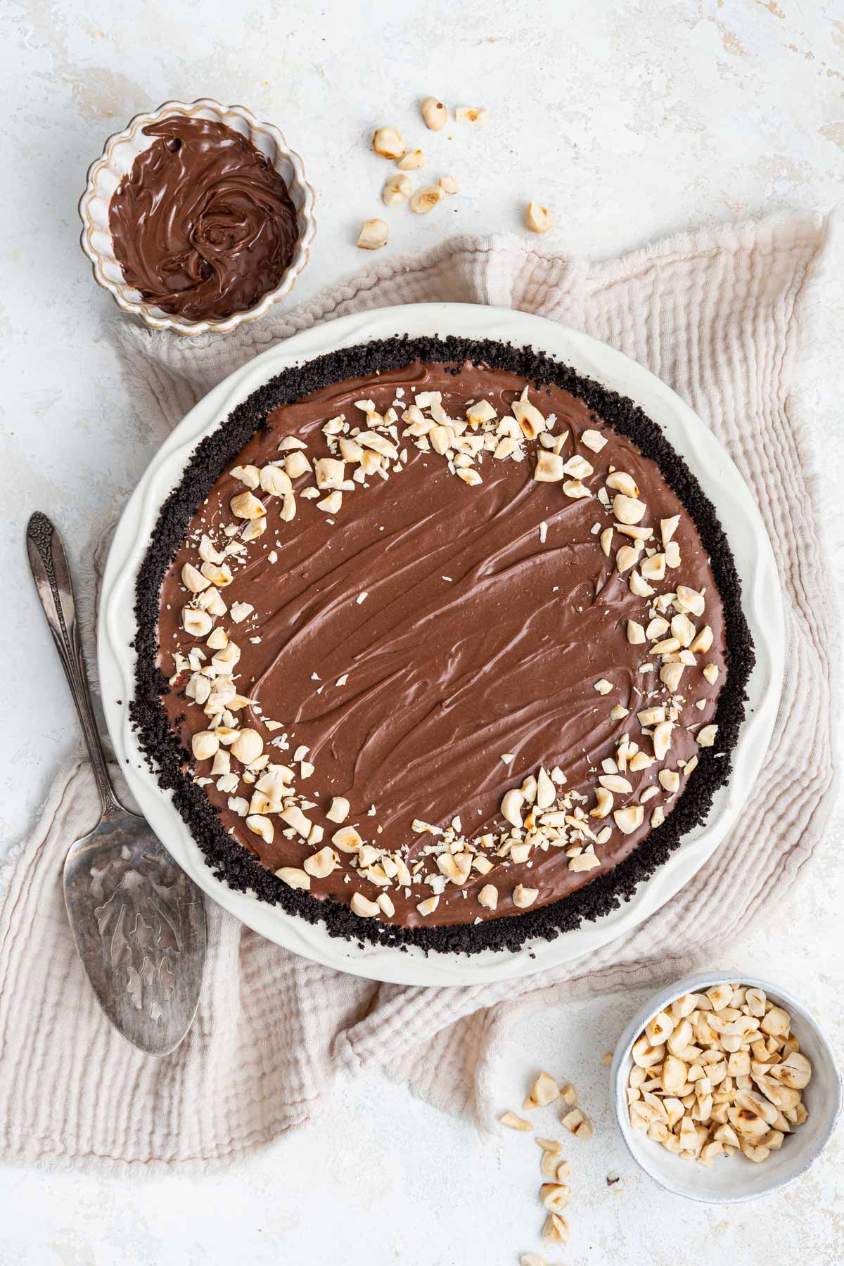 oreo pie crust filled with creamy nutella no bake filling and decorated with chopped hazelnuts