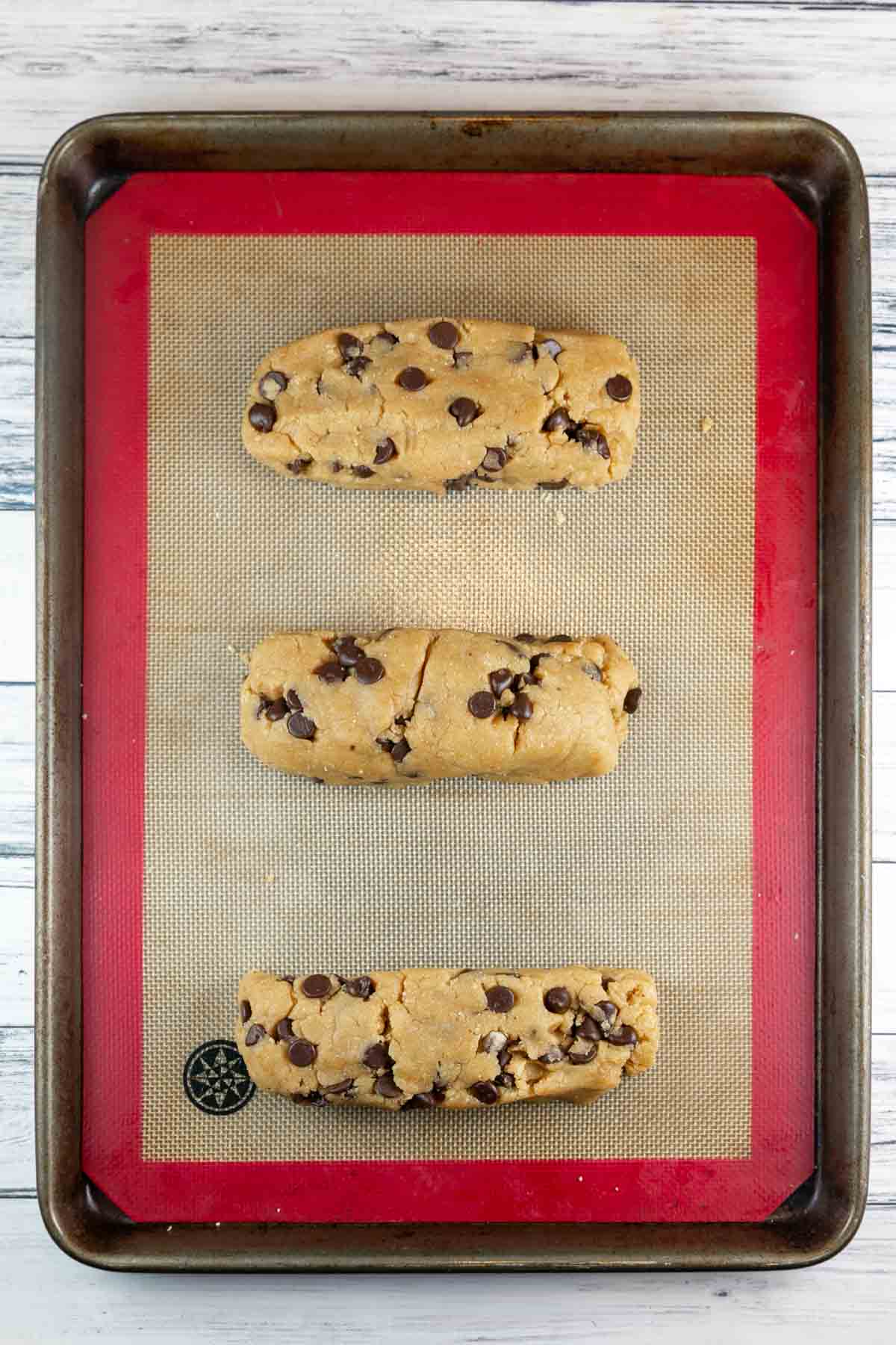 3 loaves of mandelbrot dough lined up on a baking sheet