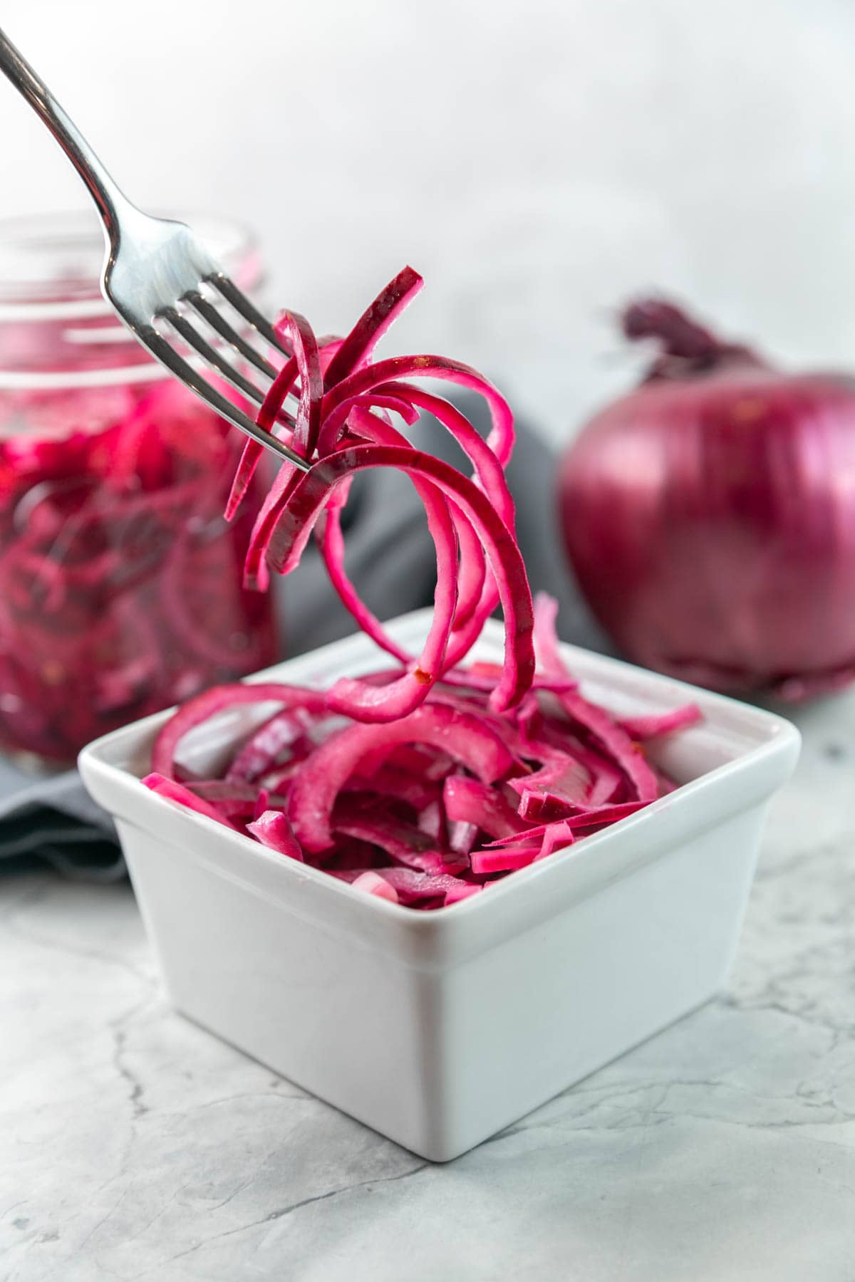 fork picking up a pile of pickled red onions