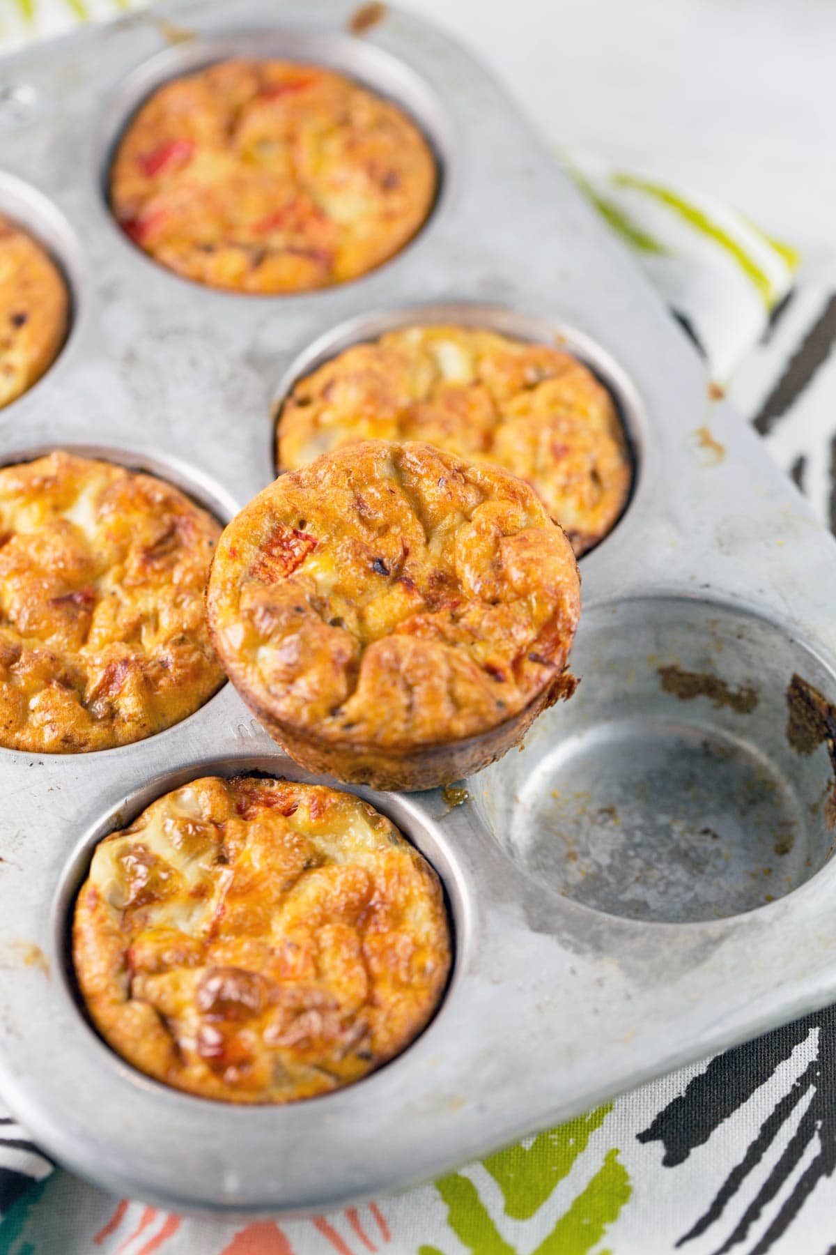 egg muffins filled with black beans and peppers in a metal muffin tin