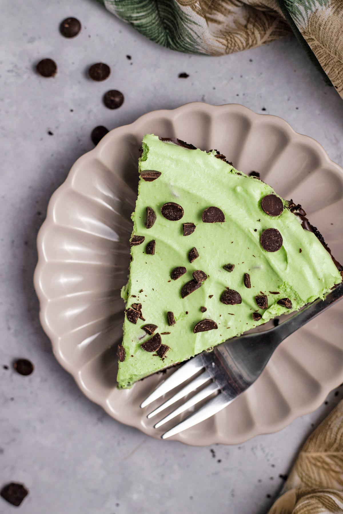 slice of green no bake mint custard pie decorated with chopped chocolate