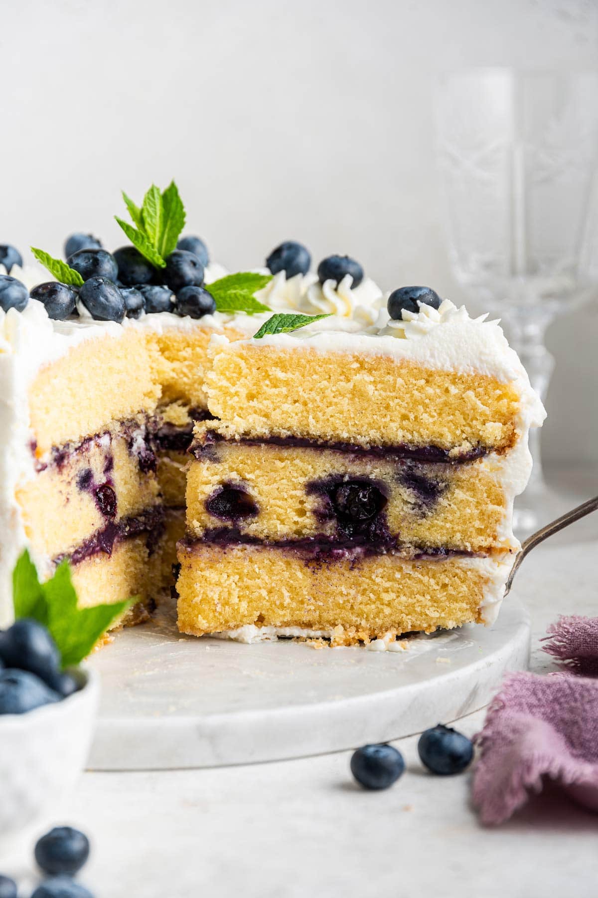 slice of cake with layers of blueberry curd on a serving spatula