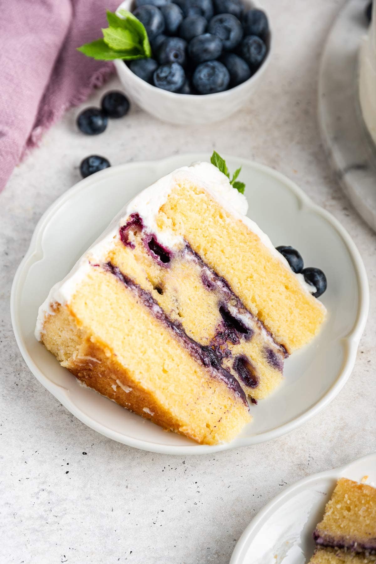 three layer blueberry birthday cake filled with curd on a decorative dessert plate