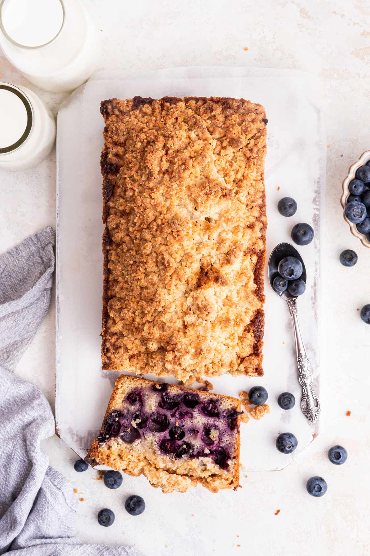 overhead view of an almond crumble topped bread with one slice cut