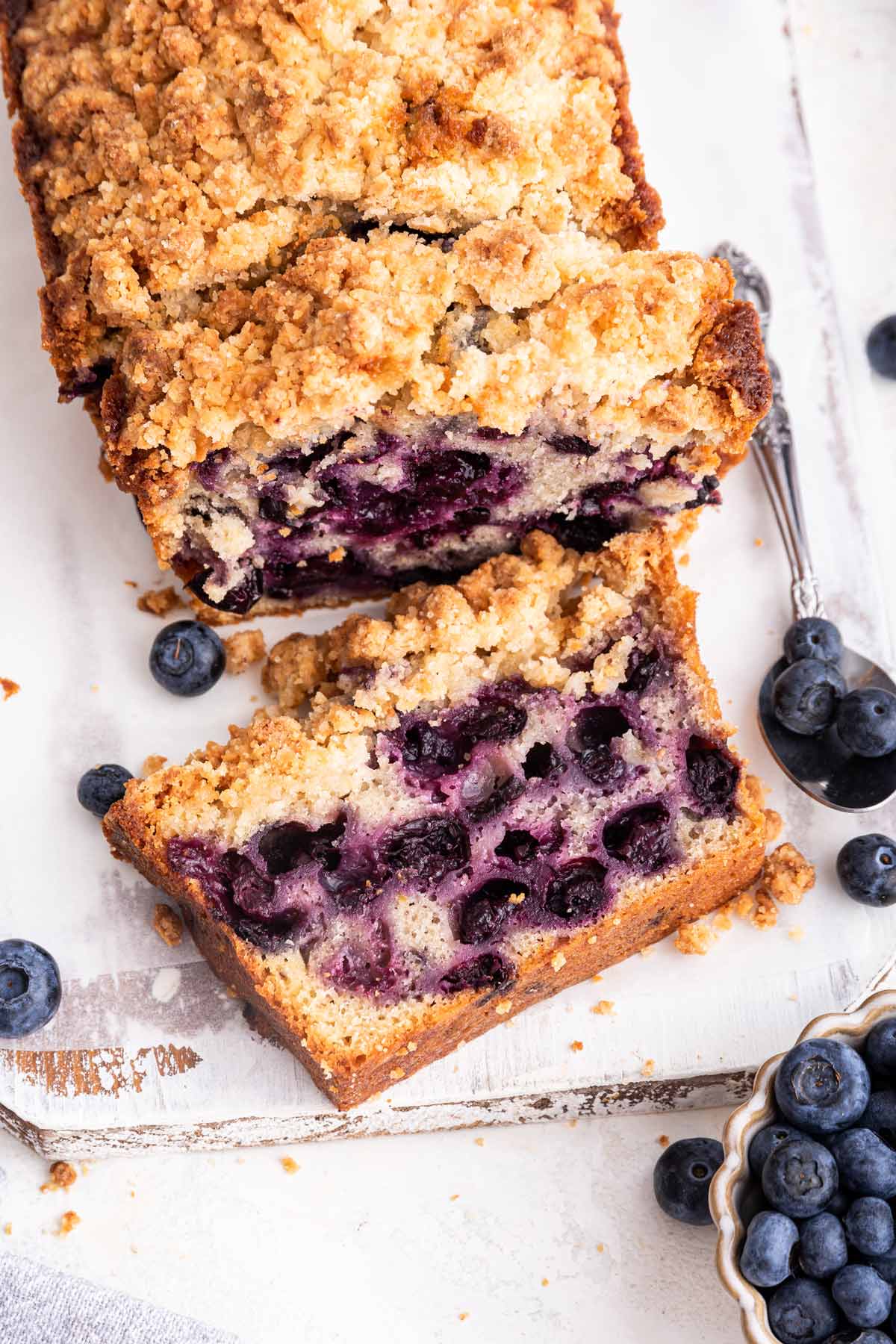 slices of blueberry pie bread on a white wooden cutting board