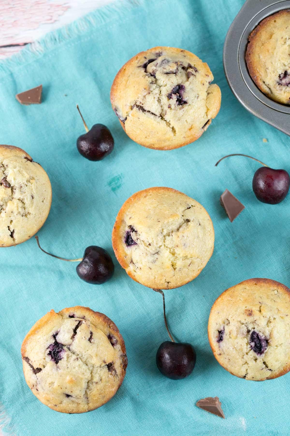 overhead view of muffins on a teal-colored kitchen towel