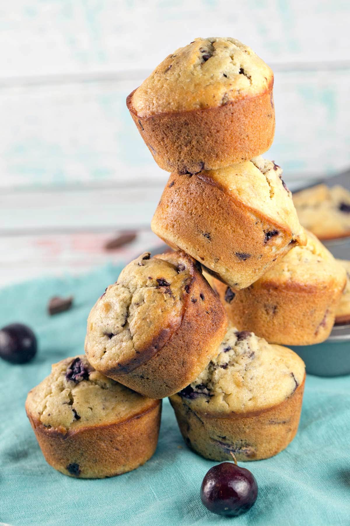 a tower of five chocolate cherry chunk muffins stacked on top of each other