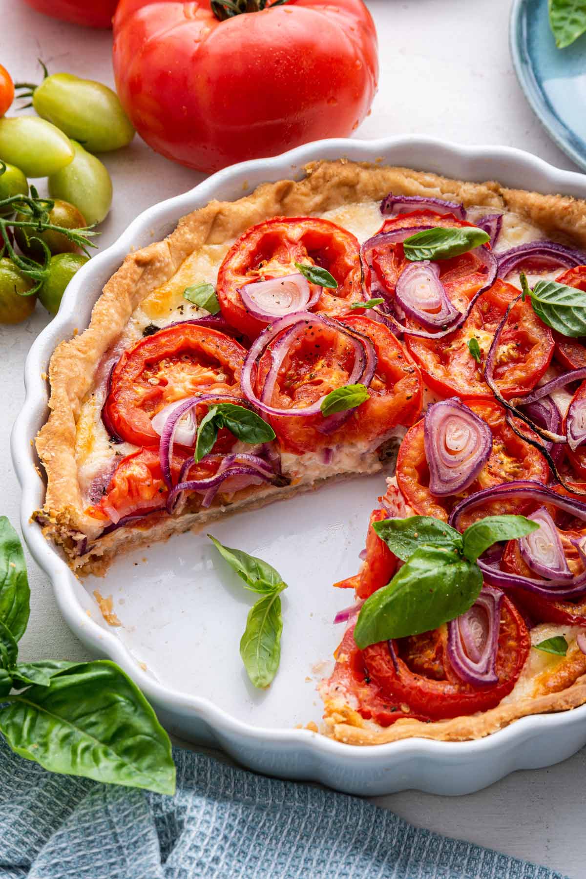 angled view showing the inside of a tomato pie with one slice removed