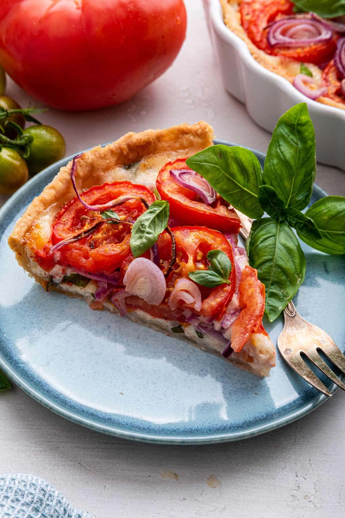 slice of tomato pie full of fresh tomatoes and basil