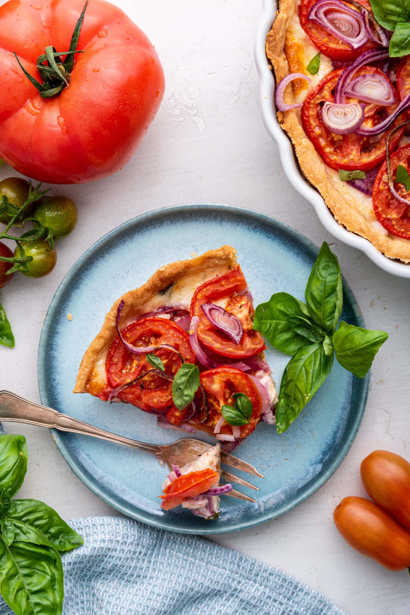 slice of tomato pie on a small blue plate