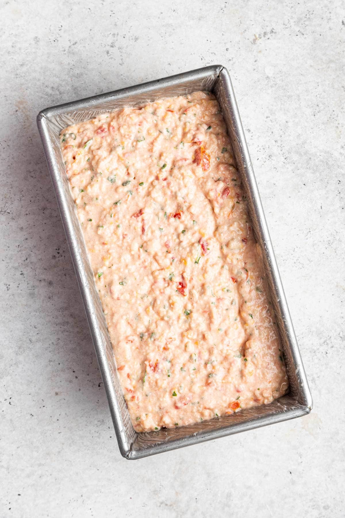 unbaked tomato quick bread in a loaf pan