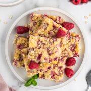 raspberry pie bars made with fresh raspberries arranged on a white plate