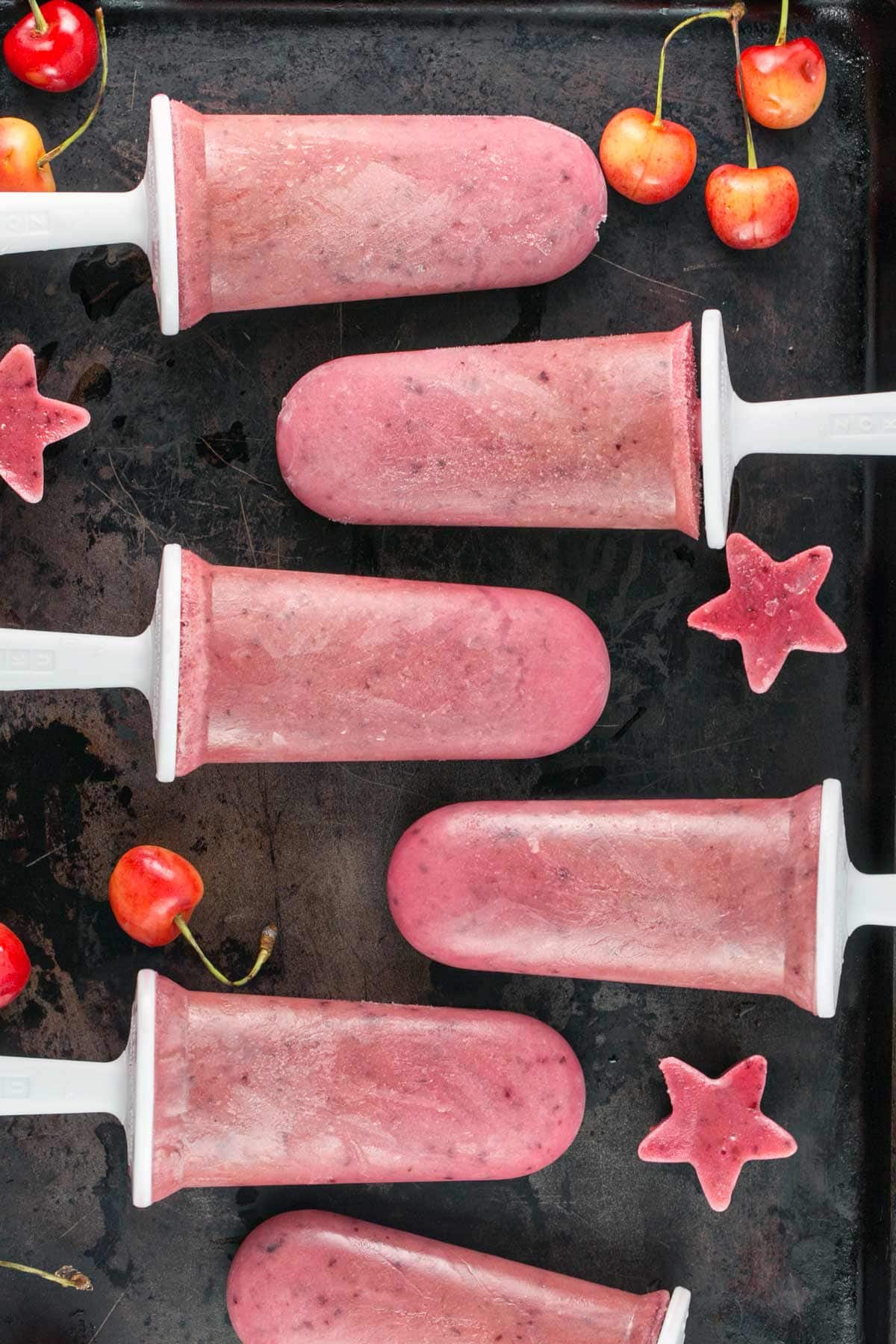 watermelon cherry popsicles on a metal sheet pan
