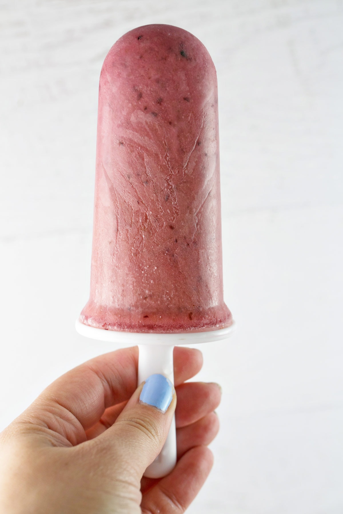 hand holding one pink watermelon cherry popsicle