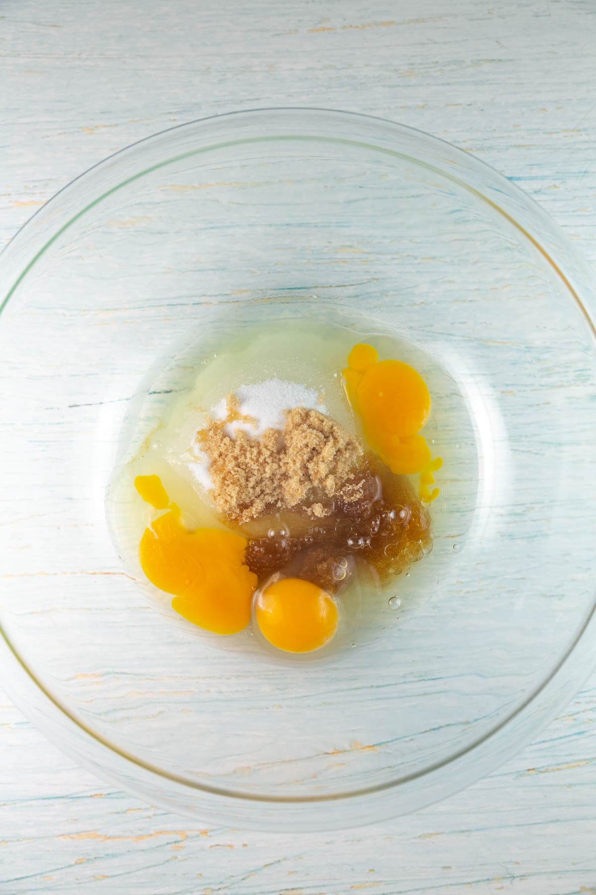 eggs oil and sugar in a glass mixing bowl