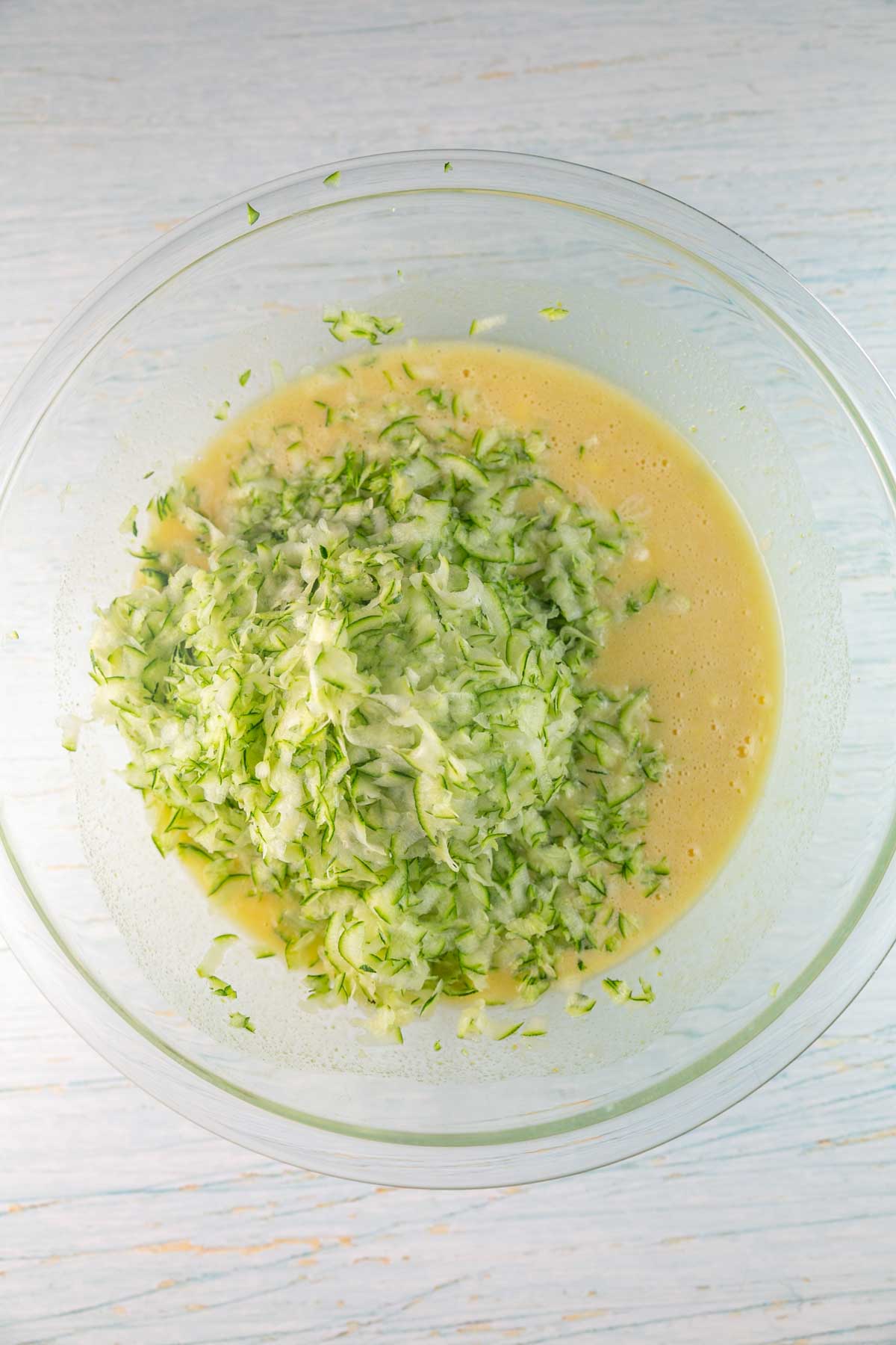 big pile of grated zucchini in a mixing bowl