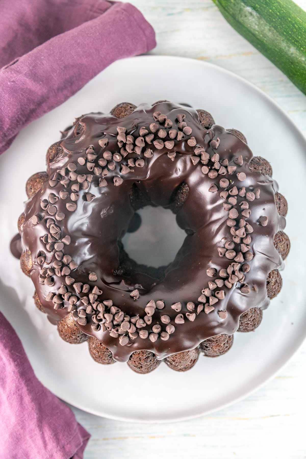 Overhead shot of zucchini bundt cake with chocolate ganache and chocolate chips on top. 