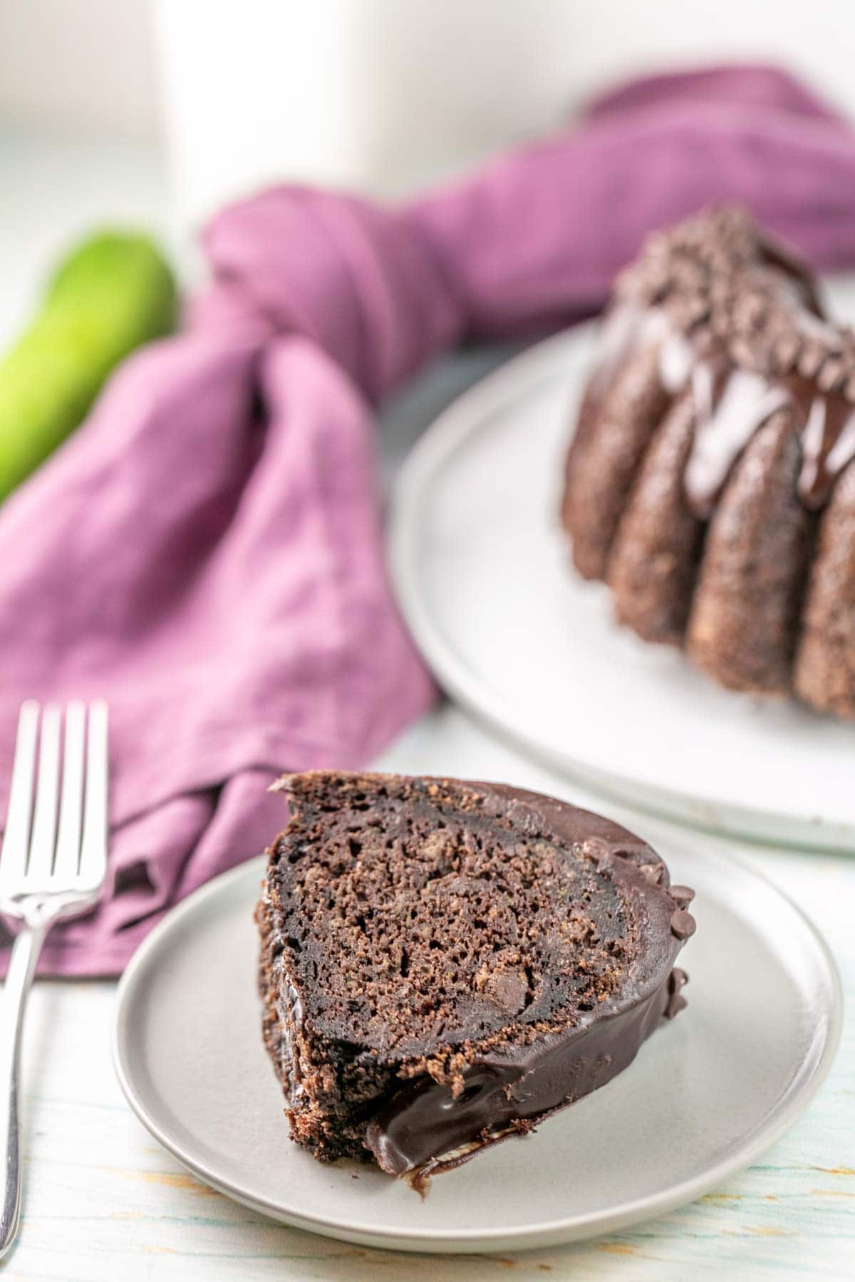 Slice of chocolate cake on a plate with a fork next to it. 