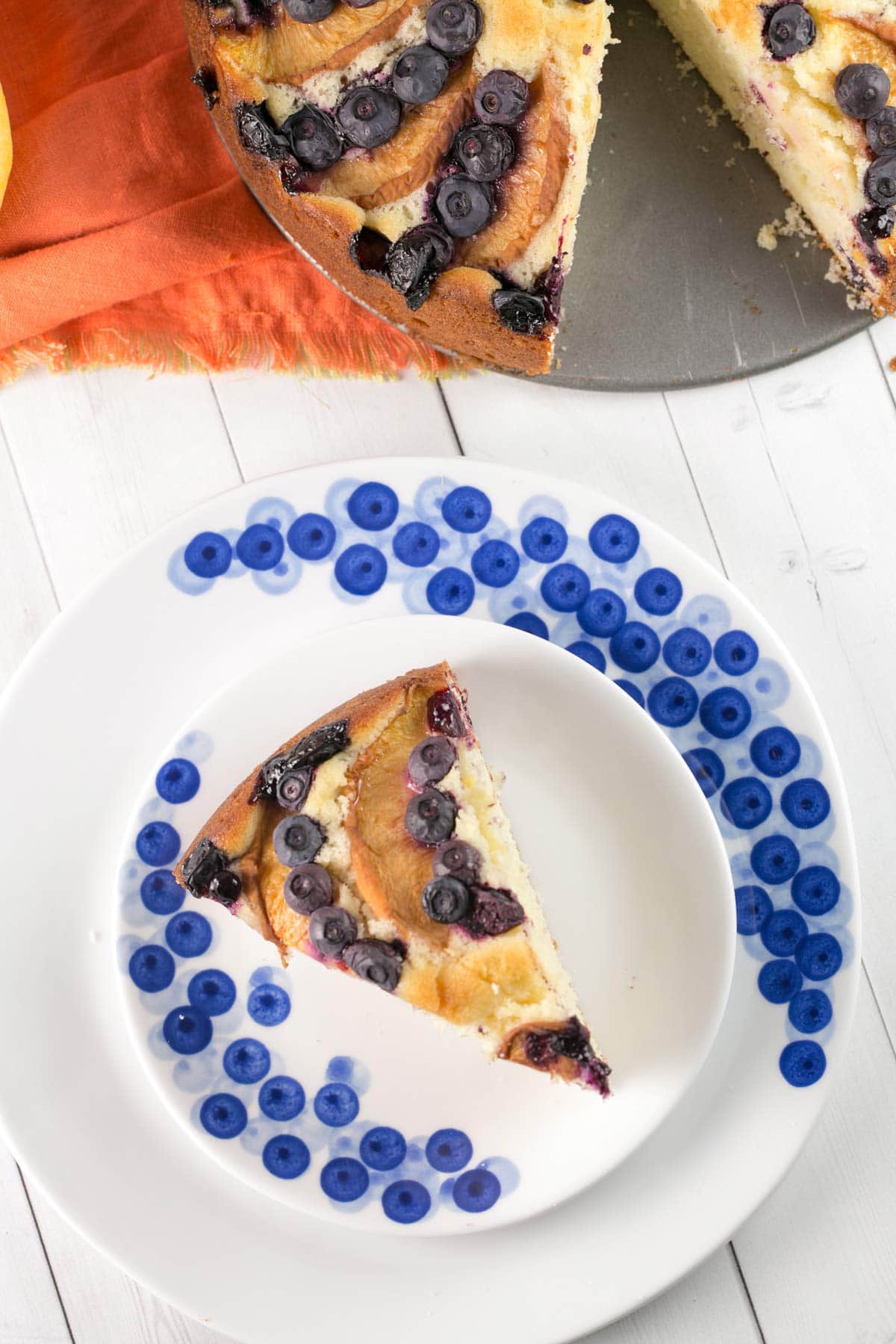 slice of blueberry peach coffee cake on decorative blueberry dessert plates