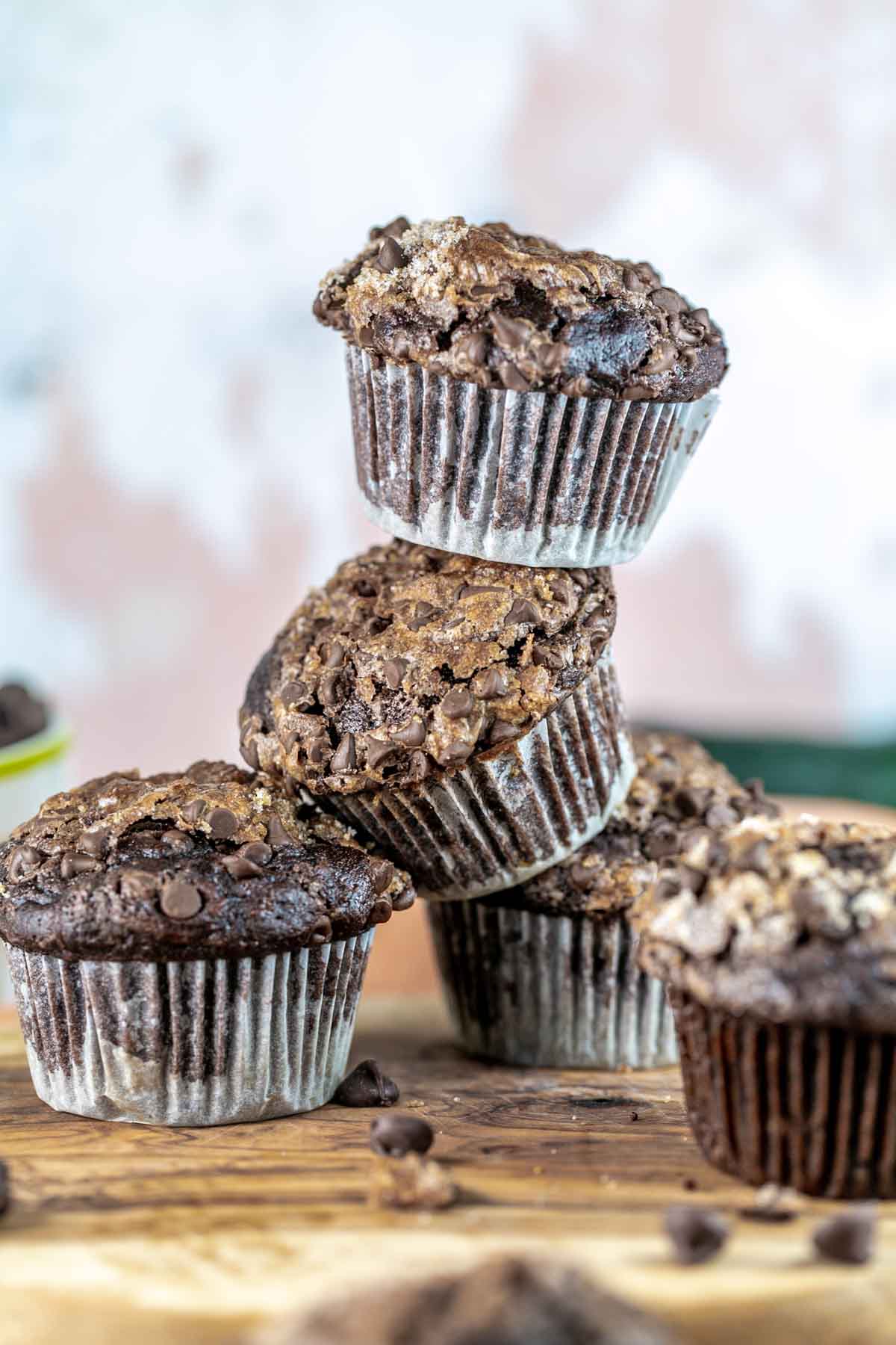 stack of multiple domed chocolate zucchini muffins piled on top of each other
